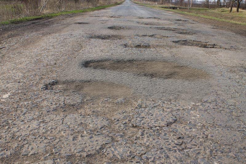 CONCRETE ROAD WITH SURFACE EROSION AND POTHOLES